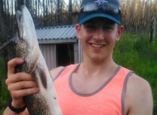 Kenny healthy and smiling holding a fish